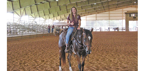 Riding a horse in arena.