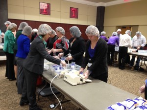 Saddle and Sirloin members packing Rice and Fortified Soy Casserole meals for Kids Against Hunger