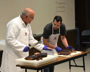 (Left) Dr. Jeff Savell, Texas A&M University distinguished professor in the department of animal science, and Aaron Franklin of Franklin Barbecue in Austin, demonstrate the proper slicing of brisket at 2015 Camp Brisket held at Texas A&M. (Texas A&M AgriLife Extension Service photo by Blair Fannin)
