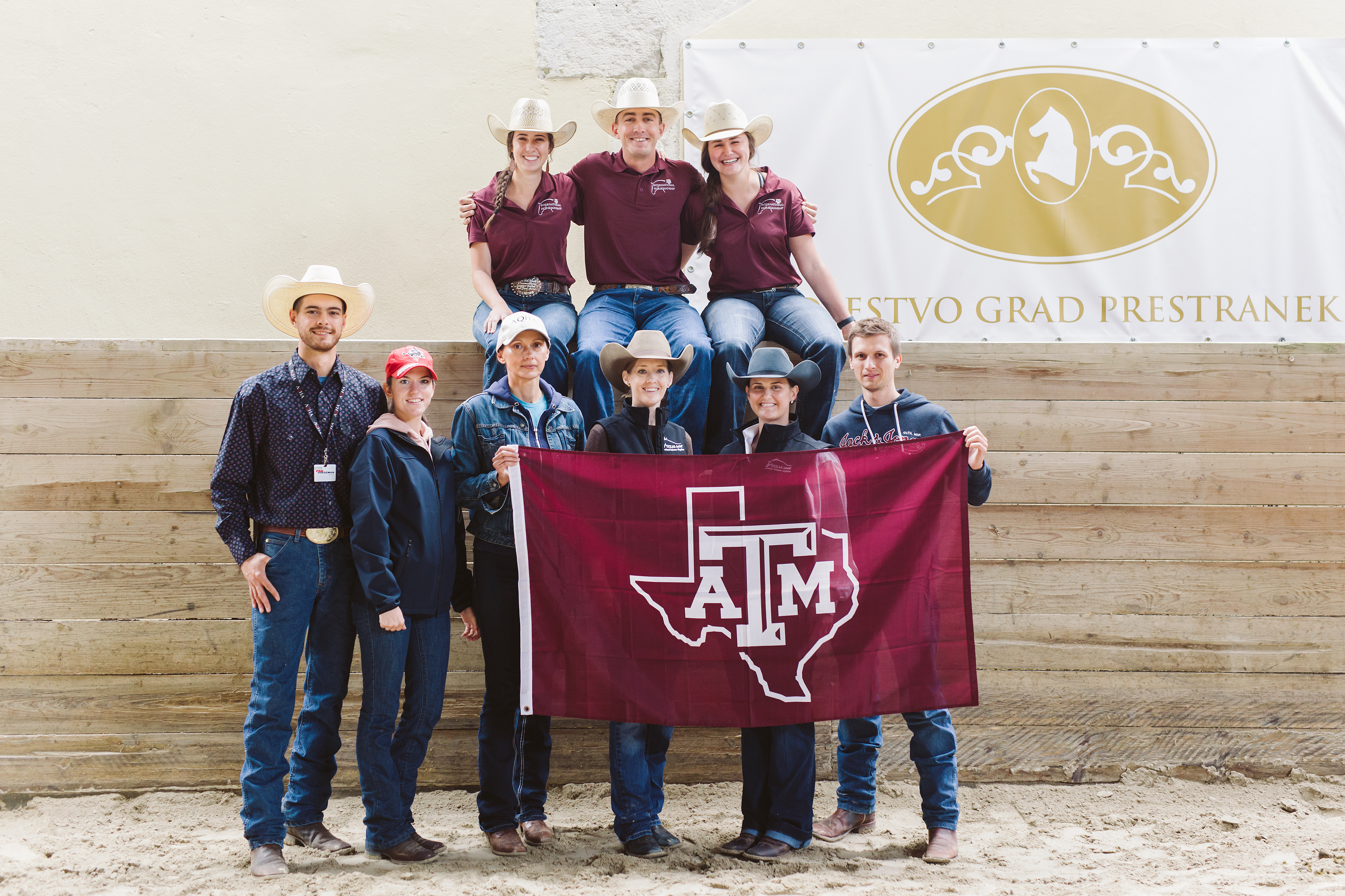 Instructors and attendees pose with aggie flag in Slovenia.