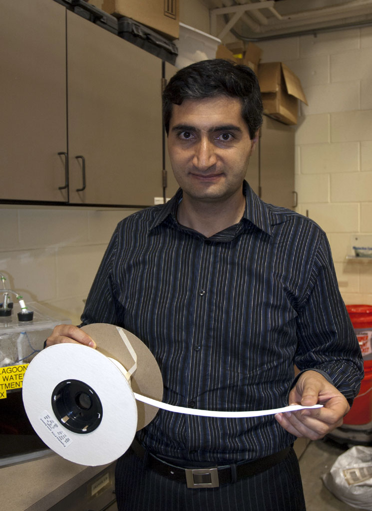 Amir Samani Majd, a doctorate candidate at the Texas A&M University department of biological and agricultural engineering, holds a spool of gas-permeable tubing that is used in the ammonia-capture process. (Texas AgriLife Extension Service photo by Robert Burns)