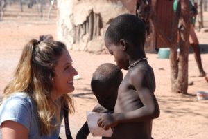 Julia Hay interacts with children from a Himba village. The taller child is female; the Himba culture utilizes necklaces to differentiate gender from a young age. 