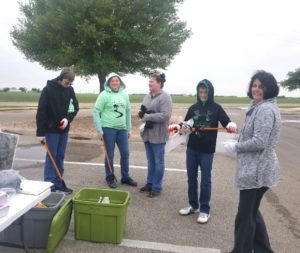 five people with trash grabbers and gloves