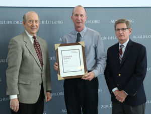 three people posing at awards ceremony