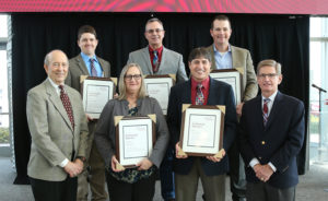 group of people posing with plaques