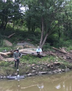 two men by creek with testing equipment
