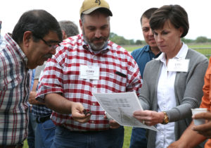 people holding soil looking at texture chart